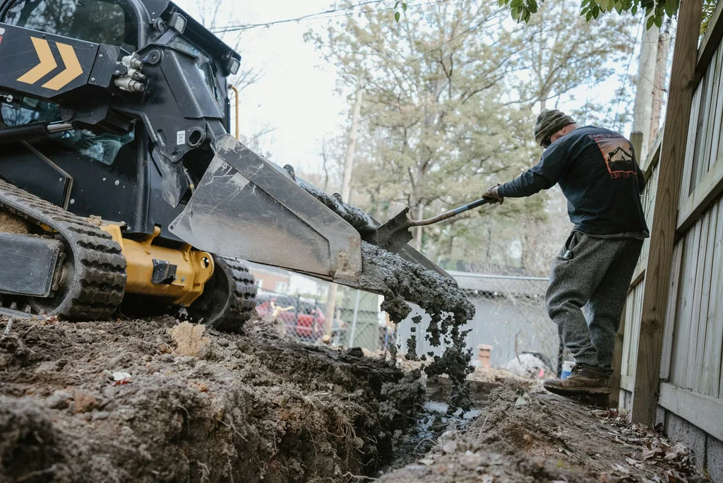 Professional plumber working on pipe installation — service imagery